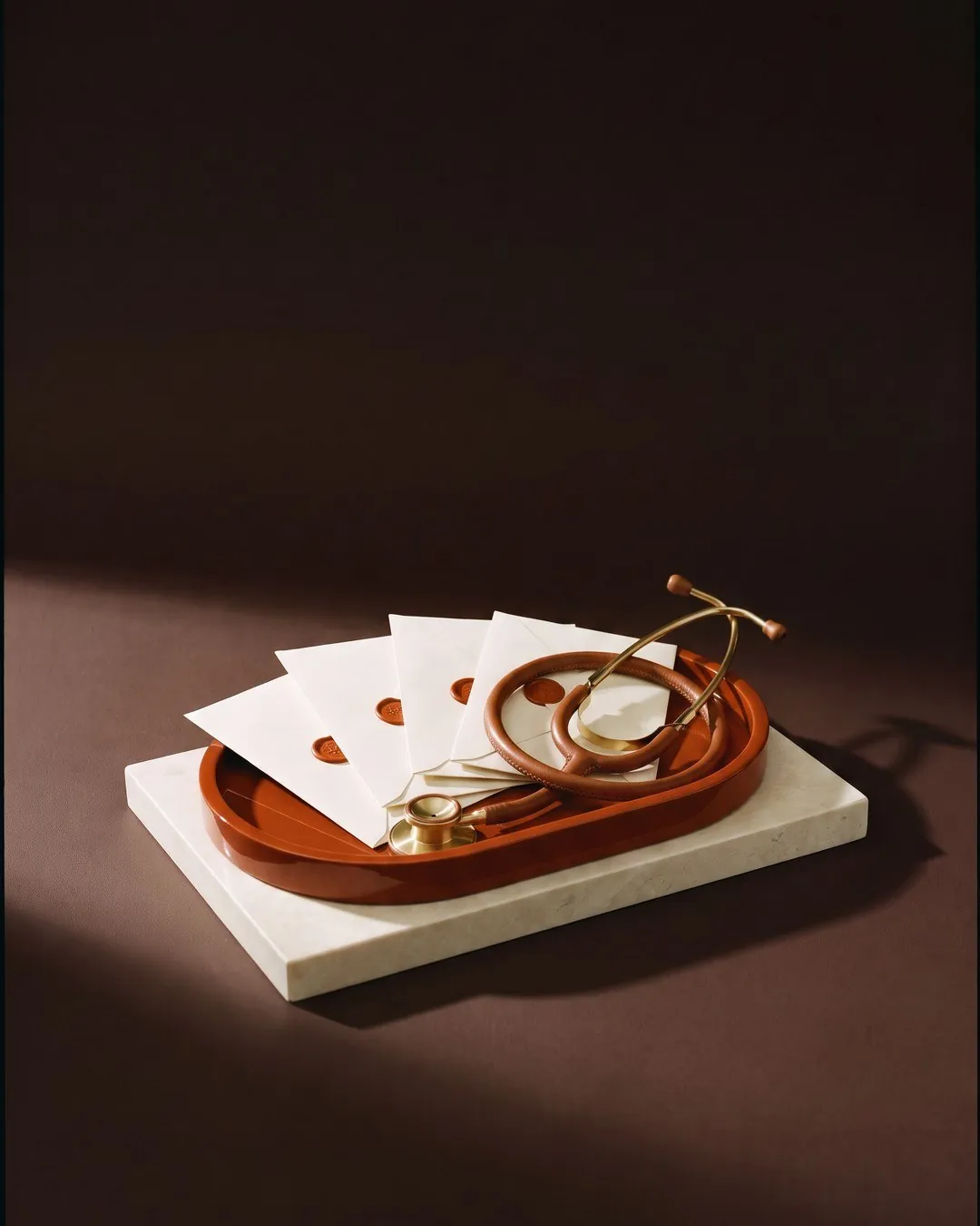 Health Optimize – sealed envelopes and a stethoscope on an orange tray